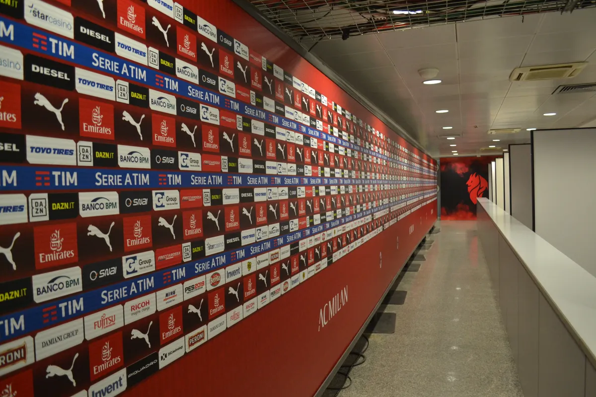 The sponsor-lined mixed zone hallway inside Stadio Giuseppe Meazza, part of the San Siro tour with kids in Milan