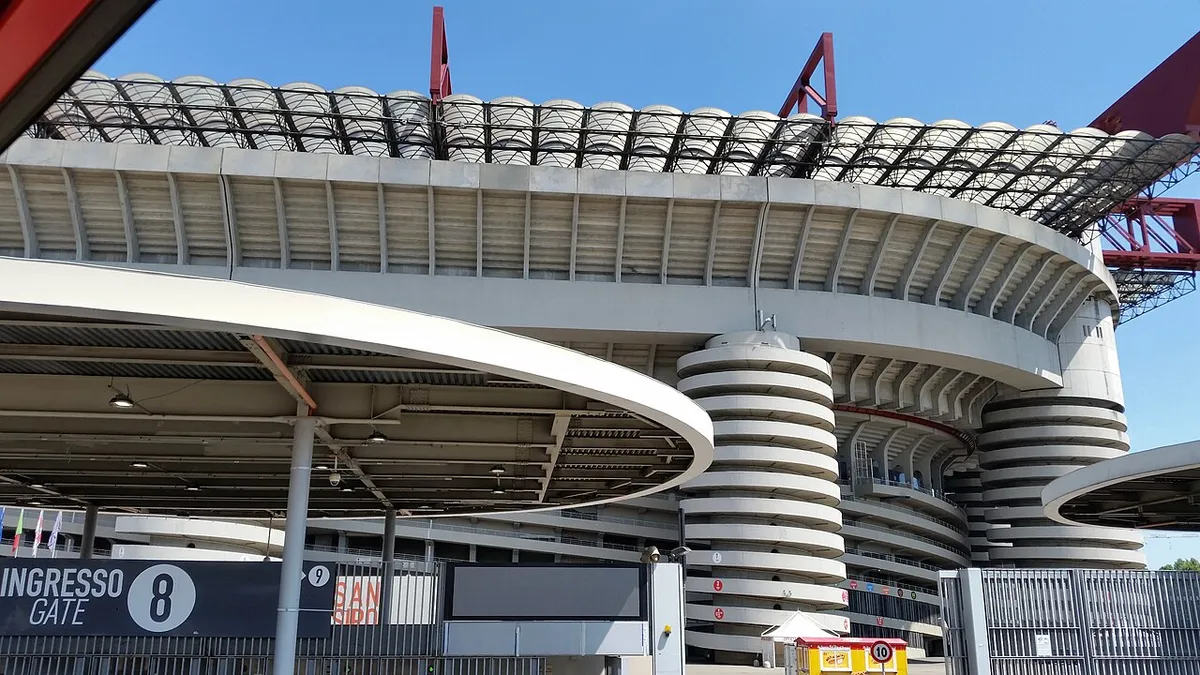 San Siro's spiral access ramps and red roof girders on a Milan stadium tour in Italy
